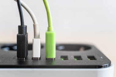 Cihazlar için modern çoklu port usb şarj cihazı. Elektrik prizinde çok renkli kabloların yakın plan görüntüsü. Makro. fişe takıldı.