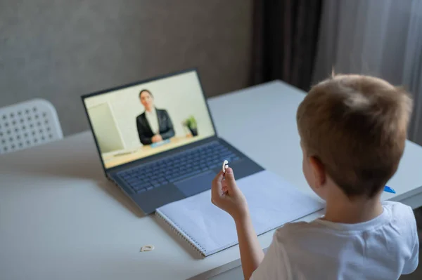 Un niño aprende el alfabeto con un profesor de portátil. Aprendizaje a distancia por videoconferencia. Educación preescolar remota. — Foto de Stock