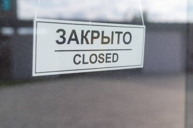 Coronavirus salgını sırasında bir kafe ya da diğer küçük işletmeler karantinaya alınır. Kapalı bir tabela cam bir kapıda asılı..