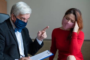 Erkek psikoterapist, tıbbi maskeli bir kadın müşteriye tavsiye eder. Salgın sırasında manevi destek. Depresyondaki kadın psikoloğa gidiyor. Koronavirüste panik atak tedavisi.