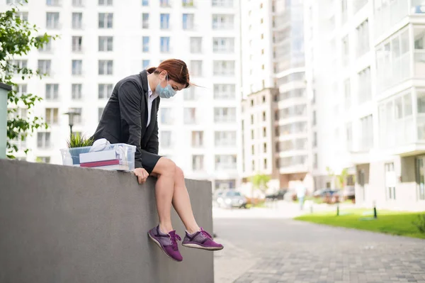 Una mujer deprimida con una máscara médica mira hacia abajo desde el borde y planea un suicidio. La gerente fue despedida de la corporación. La crisis financiera mundial y el desempleo . —  Fotos de Stock