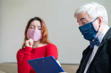 Erkek psikoterapist, tıbbi maskeli bir kadın müşteriye tavsiye eder. Koronavirüs salgını sırasında manevi destek. Depresyondaki kadın psikoloğa gidiyor. Hastalık ve panik atak tedavisi