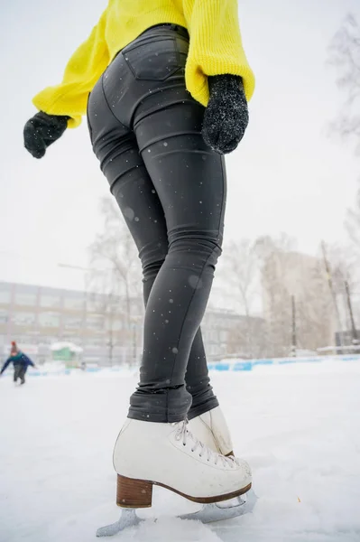 Patinação artística na rua em uma pista de gelo ao ar livre. Close-up das pernas patinadoras no gelo. Uma mulher entra para o desporto. . — Fotografia de Stock