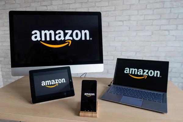Logotipo de Amazon en pantallas de ordenador, tableta digital portátil y teléfono inteligente. Aplicaciones para todos los dispositivos tienda en línea donde se puede comprar todo. Compras en línea sin salir de casa . — Foto de Stock