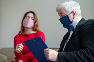 Erkek psikoterapist, tıbbi maskeli bir kadın müşteriye tavsiye eder. Koronavirüs salgını sırasında manevi destek. Depresyondaki kadın psikoloğa gidiyor. Hastalık ve panik atak tedavisi