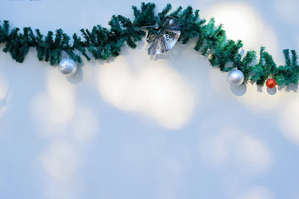 Decoração de Natal. grinalda com ramos de abeto verde ana uma parede branca . — Fotografia de Stock