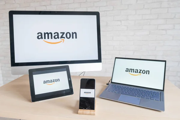 Логотип Amazon на экранах компьютеров, ноутбуков цифровых планшетов и смартфонов. Приложения для всех устройств интернет-магазина, где вы можете купить все. Интернет покупки, не выходя из дома . — стоковое фото