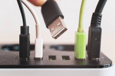 Cihazlar için modern çoklu port usb şarj cihazı. Elektrik prizine yerleştirilmiş çok renkli kabloların yakın plan görüntüsü. Makro.