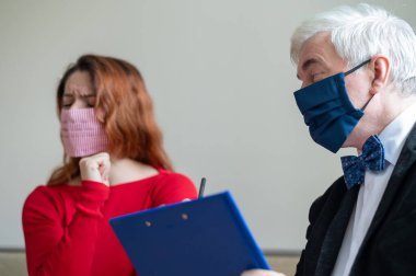 Erkek psikoterapist, tıbbi maskeli bir kadın müşteriye tavsiye eder. Koronavirüs salgını sırasında manevi destek. Depresyondaki kadın psikoloğa gidiyor. Hastalık ve panik atak tedavisi