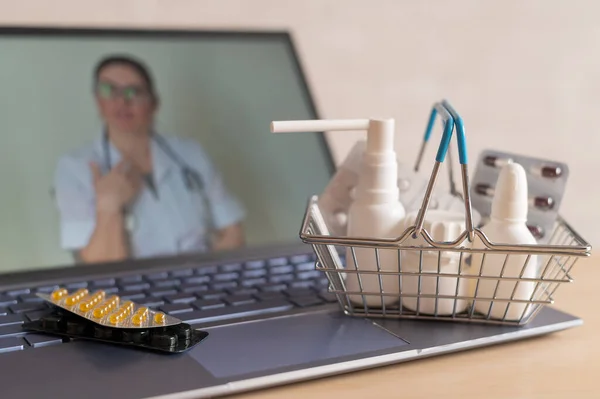 Videokonferencia egy orvossal egy laptopon és táblagépen egy kis bevásárlókosárban. Online gyógyszertár. Gyógyszerész számítógép képernyőn. — Stock Fotó