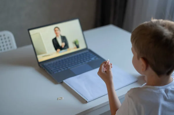 Un niño aprende el alfabeto con un profesor de portátil. Aprendizaje a distancia por videoconferencia. Educación preescolar remota. — Foto de Stock