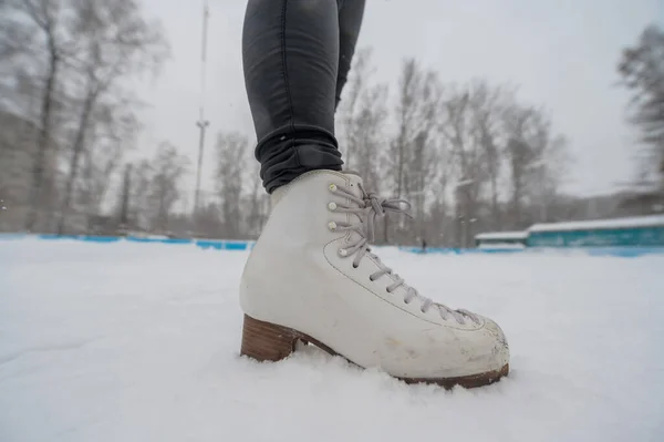 Фігурне катання на вулиці на відкритому ковзанах. Крупним планом ноги фігуристів на льоду. Жінка займається спортом . — стокове фото