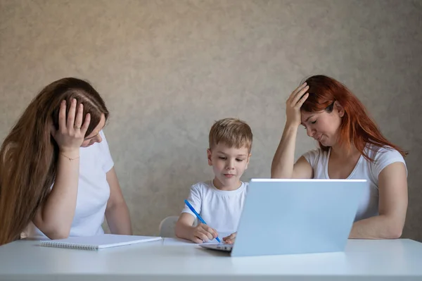 Two disgruntled women swear at their son doing homework. Female tutors swear at the boy. A lesbian couple is engaged in home schooling with a child. Distance education in quarantine.
