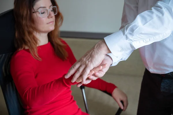 Una donna dai capelli rossi siede su una sedia con le mani chiuse e le mani alzate durante la gopnosi. Ipnoterapeuta maschio maturo in seduta con una paziente di sesso femminile. Medicina alternativa per la salute mentale. Ritagliato. — Foto Stock