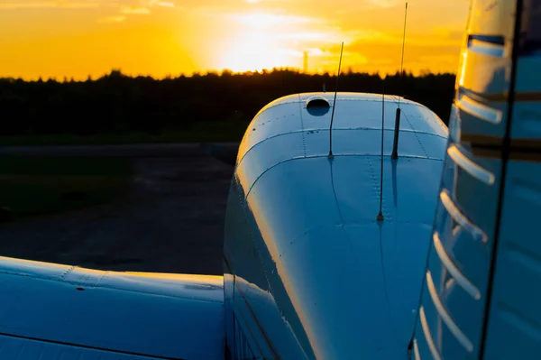 Aviones cuádruples estacionados en un aeródromo privado. Vista trasera de un avión con una hélice sobre un fondo al atardecer. — Foto de Stock