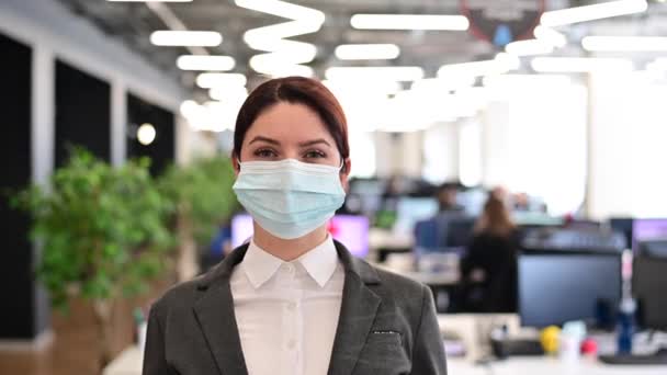 Eine fröhliche Büroangestellte im Anzug zieht die medizinische Maske ab. Eine lächelnde Frau zieht ihren Virenschutz aus. Ende der Quarantäne. Sieg über das Coronavirus. — Stockvideo