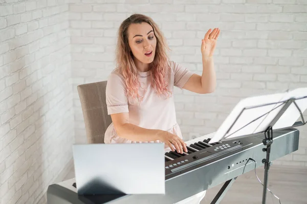 Remote music lessons. A singing teacher records the lesson on a laptop webcam.