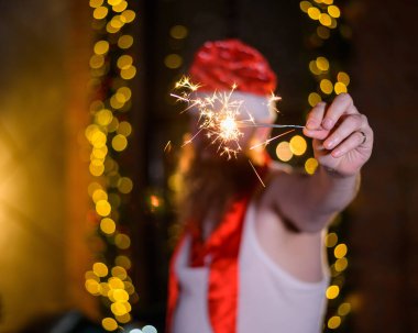 Noel Baba 'nın pırıltıları. Noel Baba şapkalı kızıl sakallı bir adam şaka olsun diye büyüleyici bir fotoğraf çekiyor..