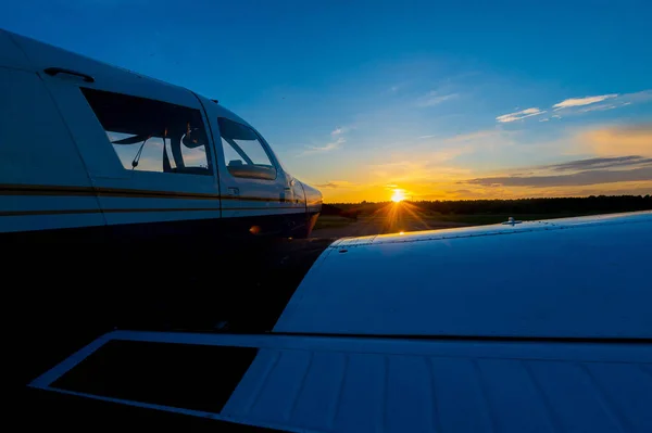 Zbliżenie małego zaparkowanego samolotu ze śrubą napędową na tle zachodu słońca. — Zdjęcie stockowe