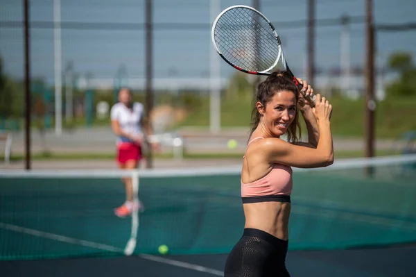 Sportovní běloška pózující s raketou na tenisovém kurtu venku. — Stock fotografie