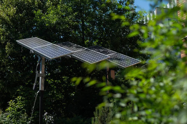 Solpaneler i grönt lövverk av träd. — Stockfoto