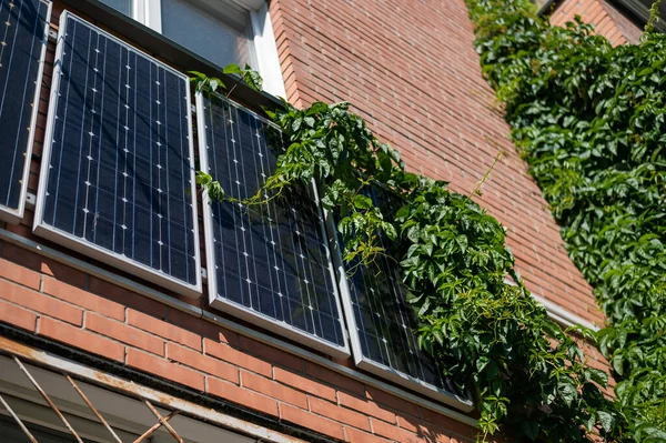 Gros plan de panneaux solaires sur un mur de briques rouges. Une autre source d'énergie. Prendre soin de l'environnement. — Photo