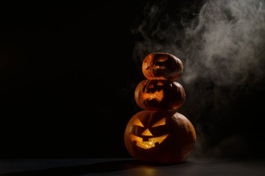 Üç Cadılar Bayramı balkabağı peş peşe duruyor. Geleneksel tatil süsü. Tebrik kartı olarak kullanışlı. Şaka mı şeker mi?.