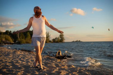 Sahilde poz veren acımasız bir adam. Çekici bir kızın parodisi..