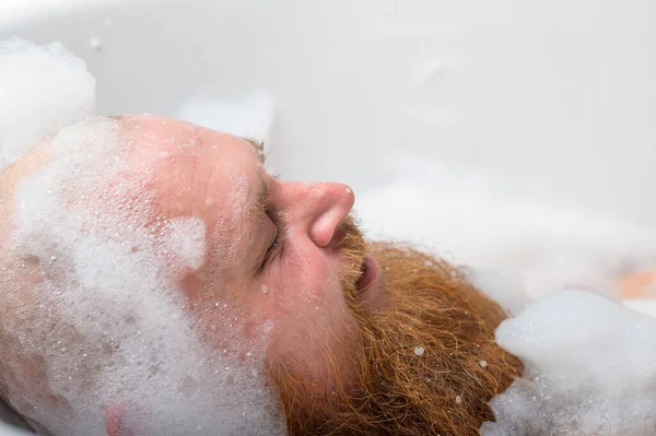 Retrato de cerca de un calvo de barba roja tomando un baño con espuma — Foto de Stock