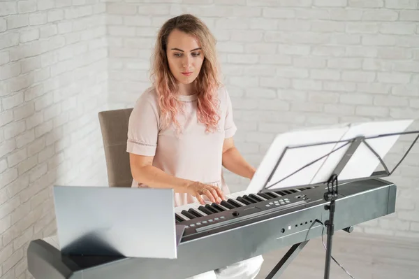 Remote music lessons. A singing teacher records the lesson on a laptop webcam.