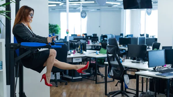 Zakenvrouw doet oefeningen op de gemonteerde horizontale balk in het kantoor. Sport tijdens een pauze op het werk. — Stockfoto