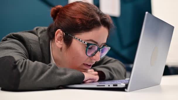 De vrouw geeuwt en valt in slaap op een laptop aan het bureau in het kantoor — Stockvideo