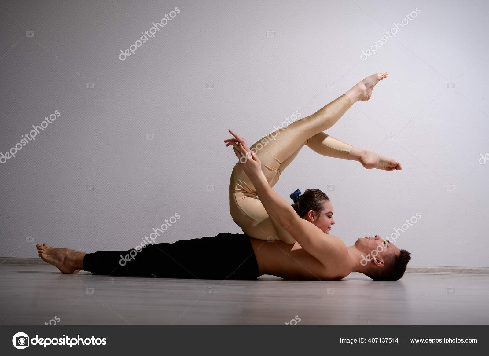 곡예사들의 쌍이 한 쌍의 속임수를 보여 주고 있습니다. 체조를 하는 여자가 셔츠를 입지 않은 남자 위에 손을 얹고 앉아 허리를 감싸고  있다. 매우 유연 한 서커스 연주가들. — 스톡 사진 © inside-studio #, image size:1600x1165