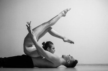 Ağır sirk pozu. Genç bir adam esnek bir kadını tutuyor. Beyaz arka planda poz veren iki akrobat ya da balerin. Bir çift jimnastikçi sanat icra ediyor..