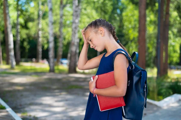 Okuldan dönerken elinde kitap tutan üzgün kız..