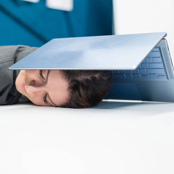 Mulher de negócios exausta cabeça coberta com laptop. Trabalhadora cansada com um computador por cima da cabeça. — Fotografia de Stock