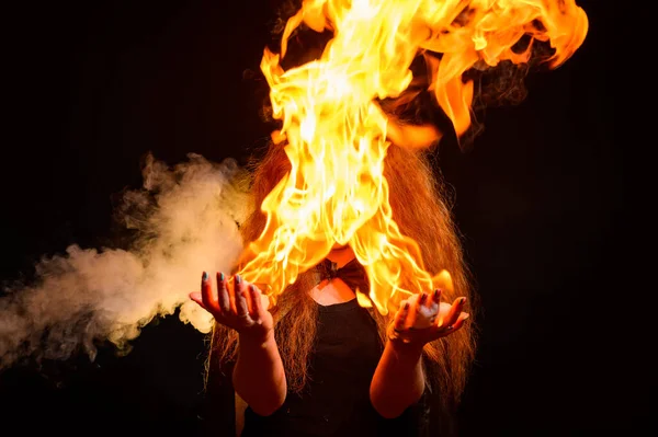 Uma bruxa ruiva malvada segura fogo em suas mãos. — Fotografia de Stock