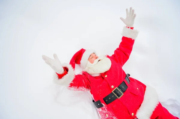 Heureux Père Noël claus couché dans la neige et de s'amuser autour — Photo