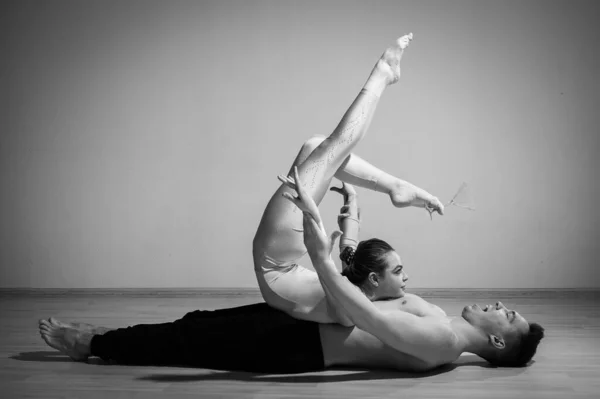 Posata da circo pesante. Un giovane uomo ha una donna flessibile. Due acrobati o ballerini che posano su uno sfondo bianco. Un paio di ginnaste eseguono arte. — Foto Stock