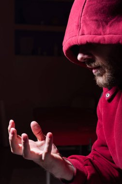 Karanlıktaki kapüşonlu şüpheli sakallı adam.