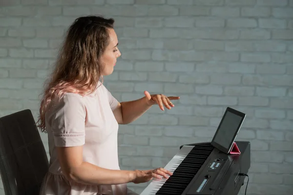 Female singing teacher at online lesson on digital tablet