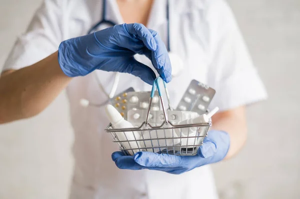 En ansiktslös kvinnlig läkare håller i en minikorg med mediciner — Stockfoto