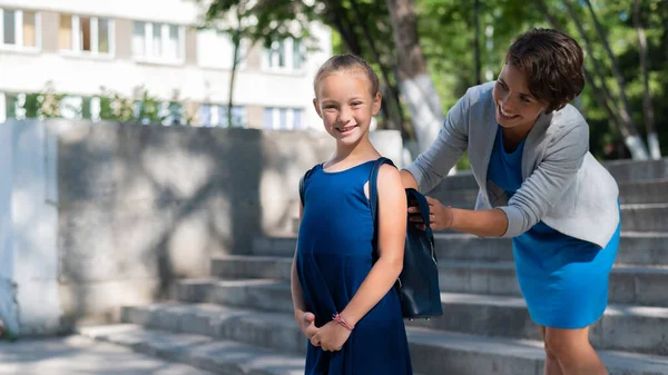 Kavkazská žena pomáhá své dceři připravit se do školy — Stock fotografie