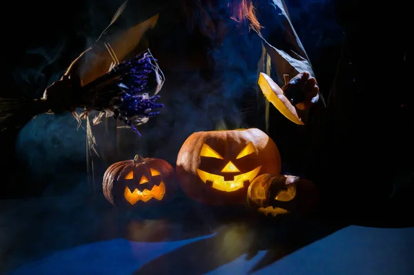 魔女はハロウィンの暗闇の中で蒸しカボチャに呪文を投げます — ストック写真