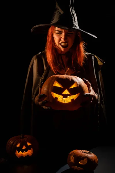 Bruja malvada sosteniendo una linterna jack-o para Halloween — Foto de Stock