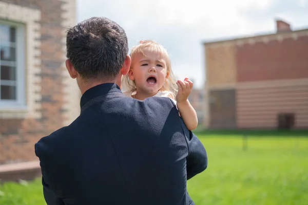 Fürsorglicher Vater hält seine kleine Tochter im Freien an den Händen. — Stockfoto