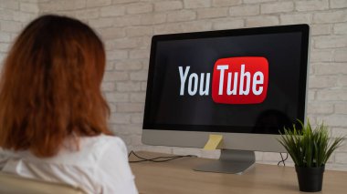 16 Eylül 2020 Rusya, Novosibirsk: Ekranda YouTube logosu olan bir kadının bilgisayar başında oturması.