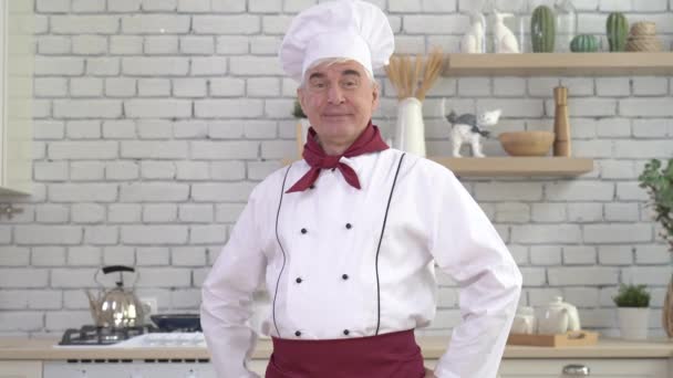 Oudere mannelijke chef poseren in de keuken — Stockvideo