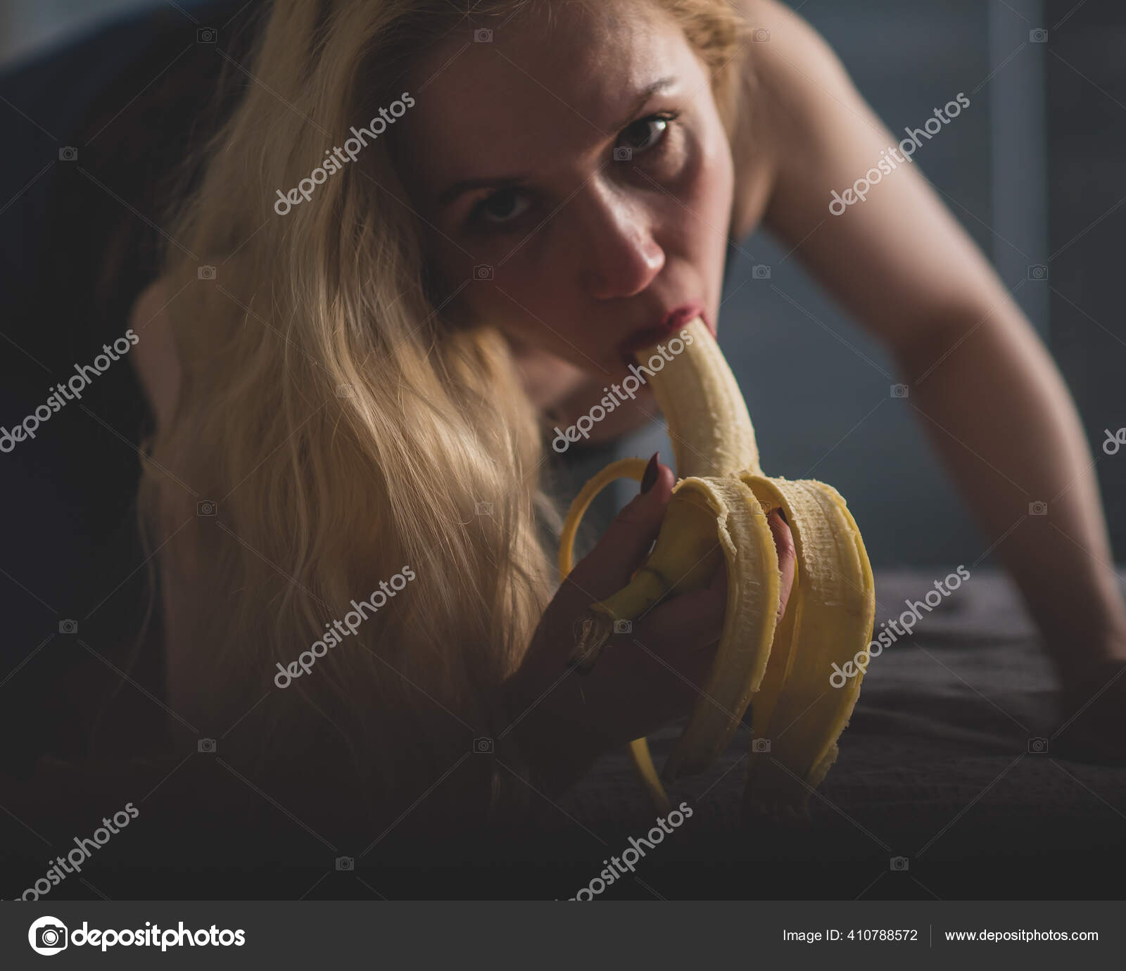 The blonde imitates oral sex and sucks a banana Stock Photo by ©inside-studio 410788572