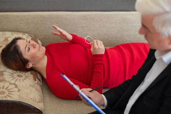 Egy nő fekszik a kanapén egy pszichoterápiás kezelés alatt. — Stock Fotó